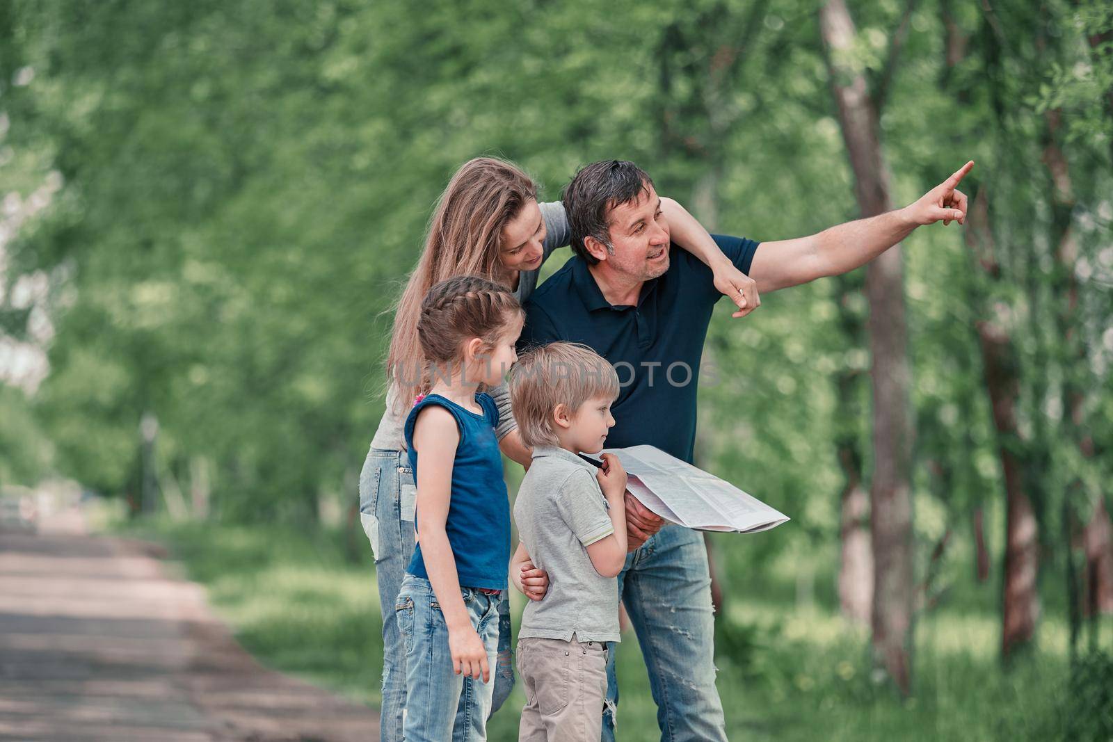 family with children discussing the route of travel on the map . family holiday concept