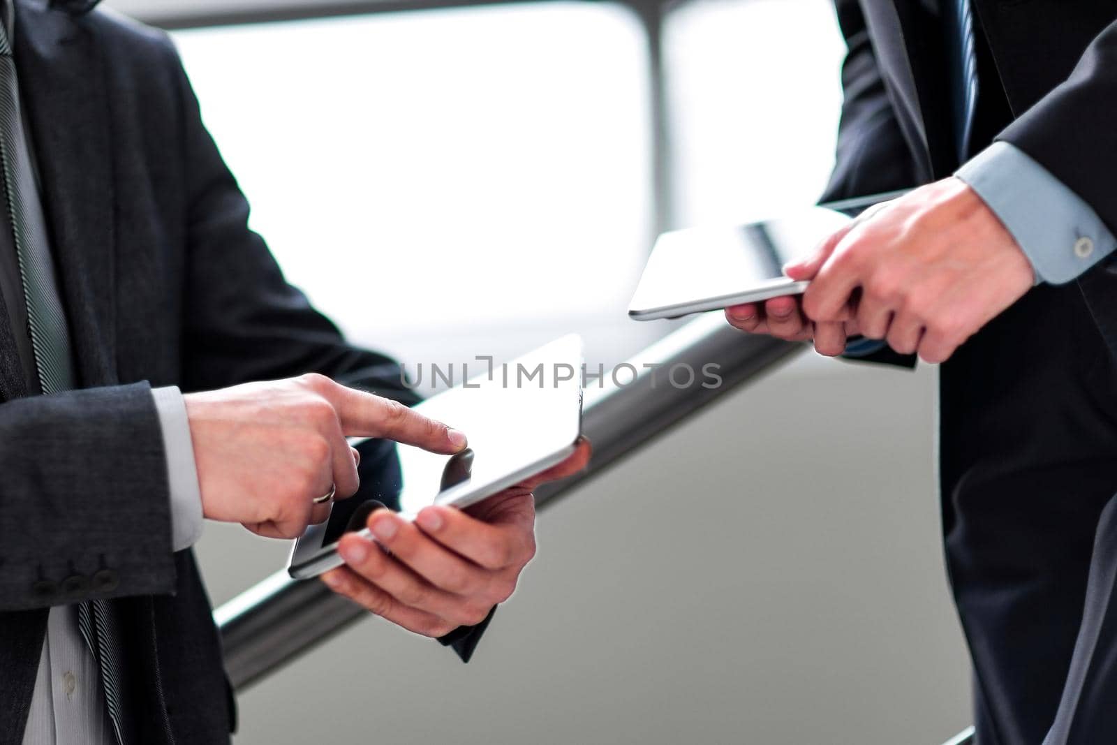 two businessmen with tablet computers.