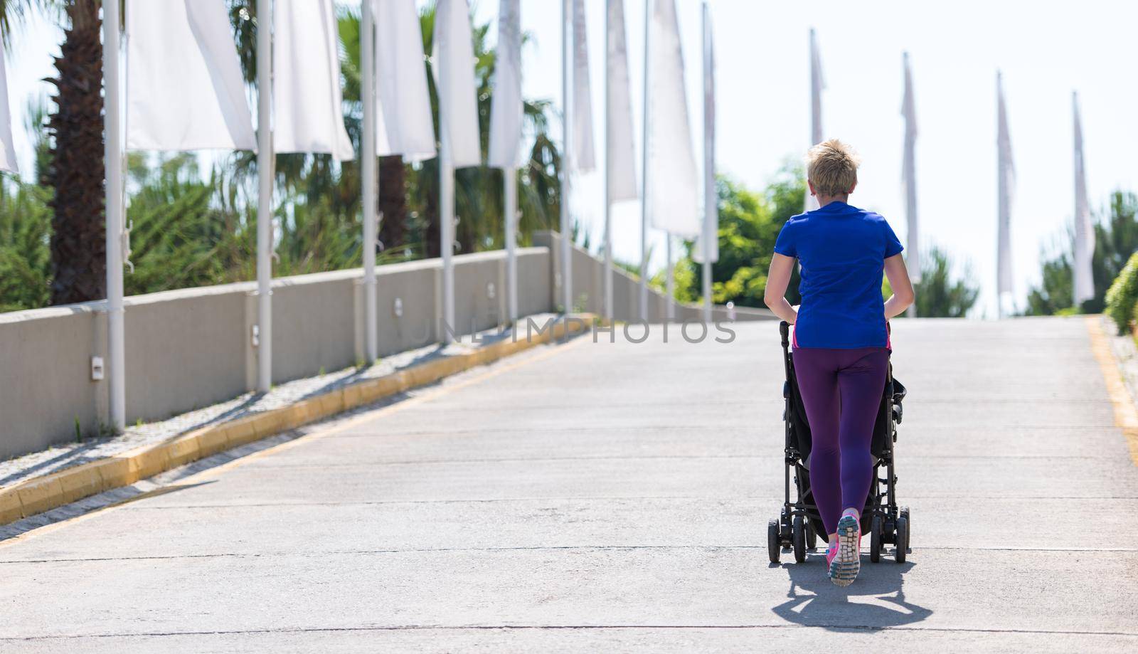 mom with baby stroller jogging by dotshock