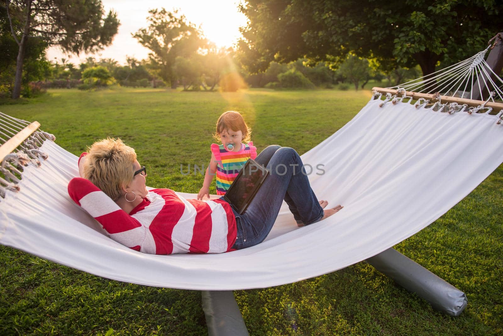 mom and a little daughter relaxing in a hammock by dotshock
