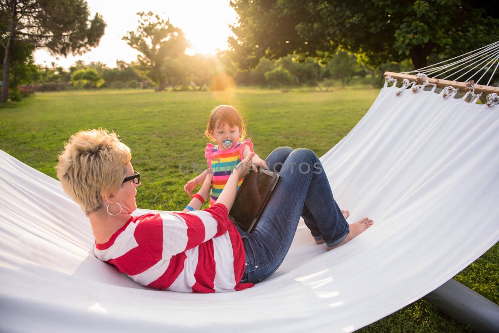 mom and a little daughter relaxing in a hammock by dotshock