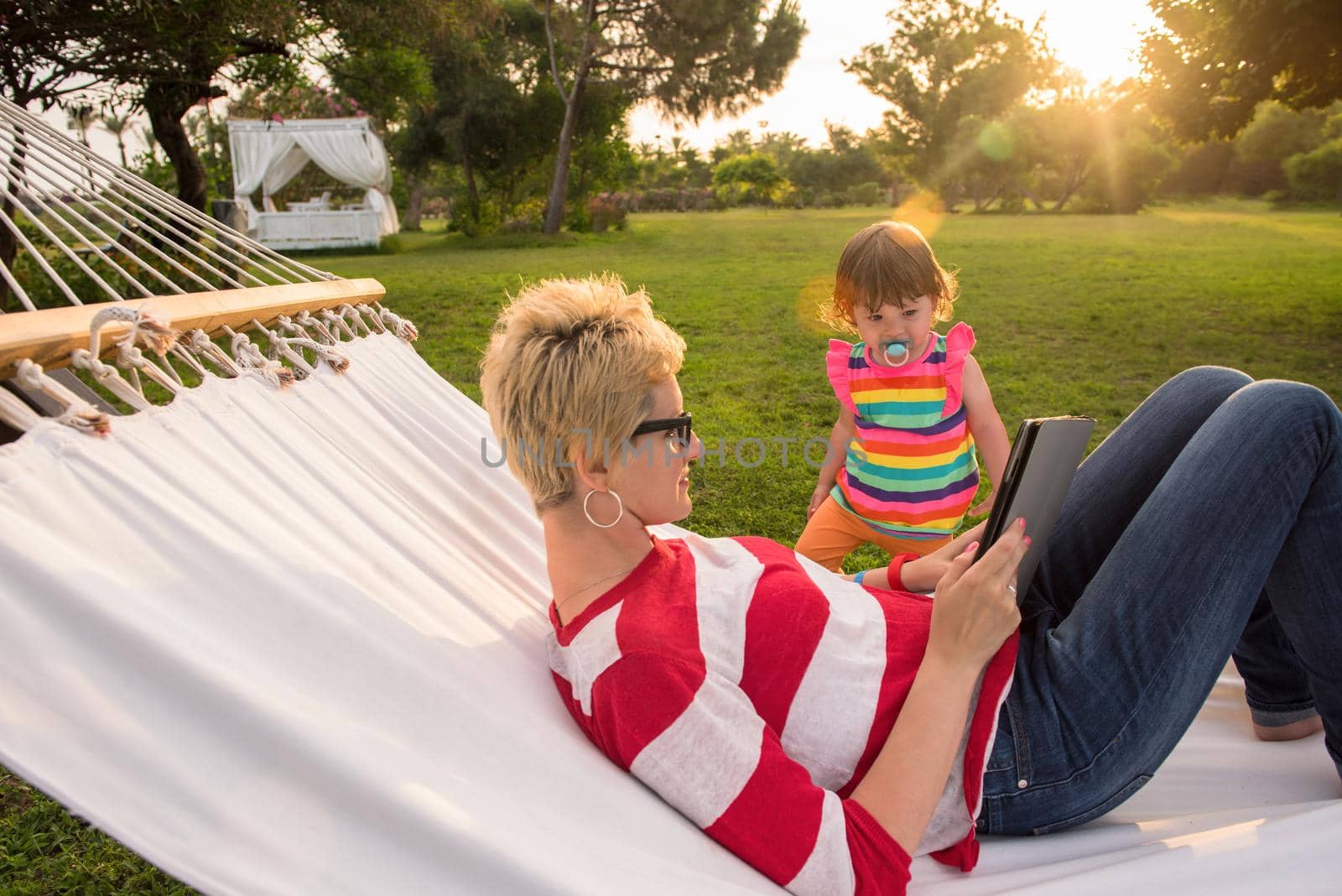 mom and a little daughter relaxing in a hammock by dotshock