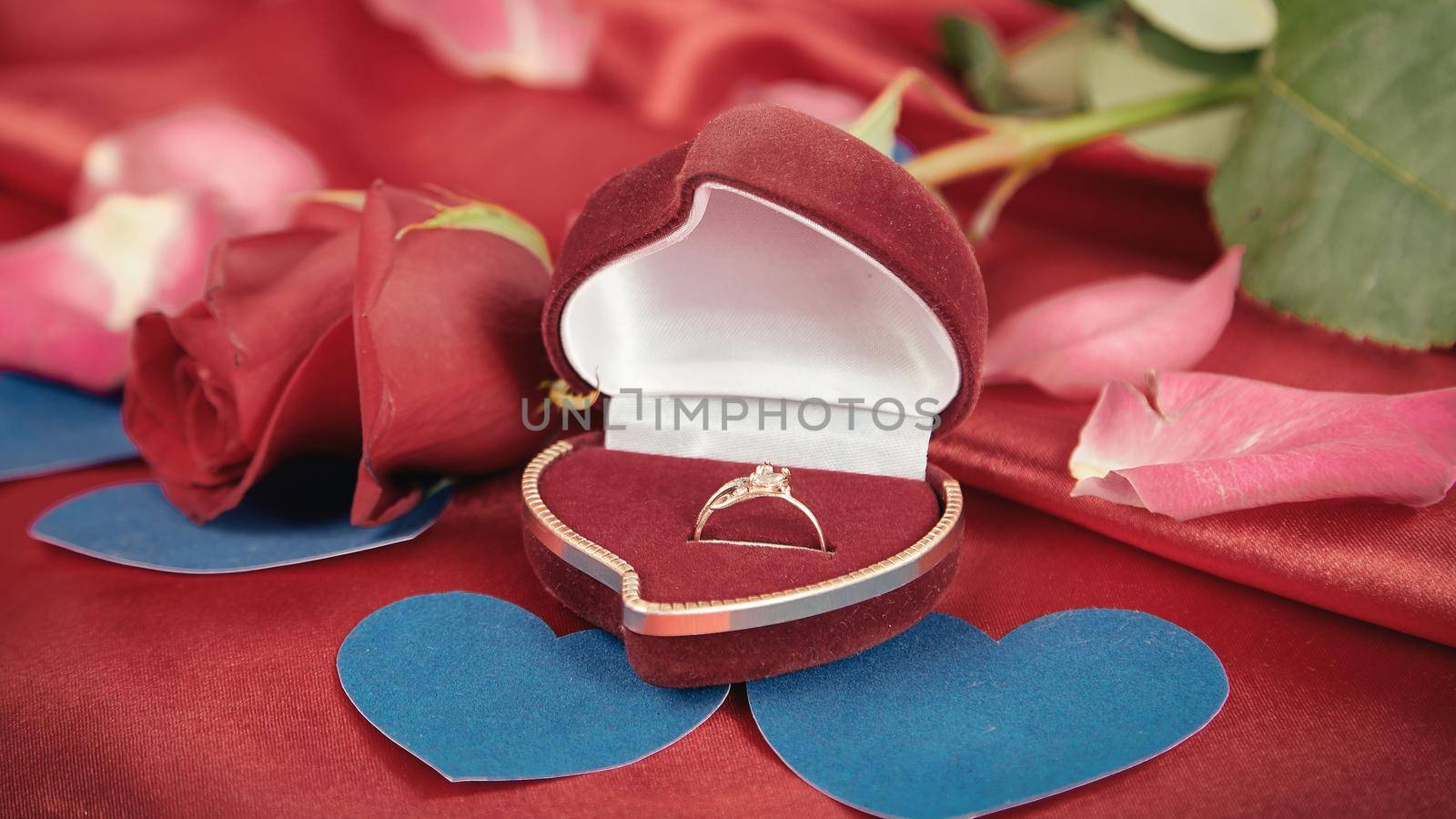 ring with a diamond on a red background . photo with copy space