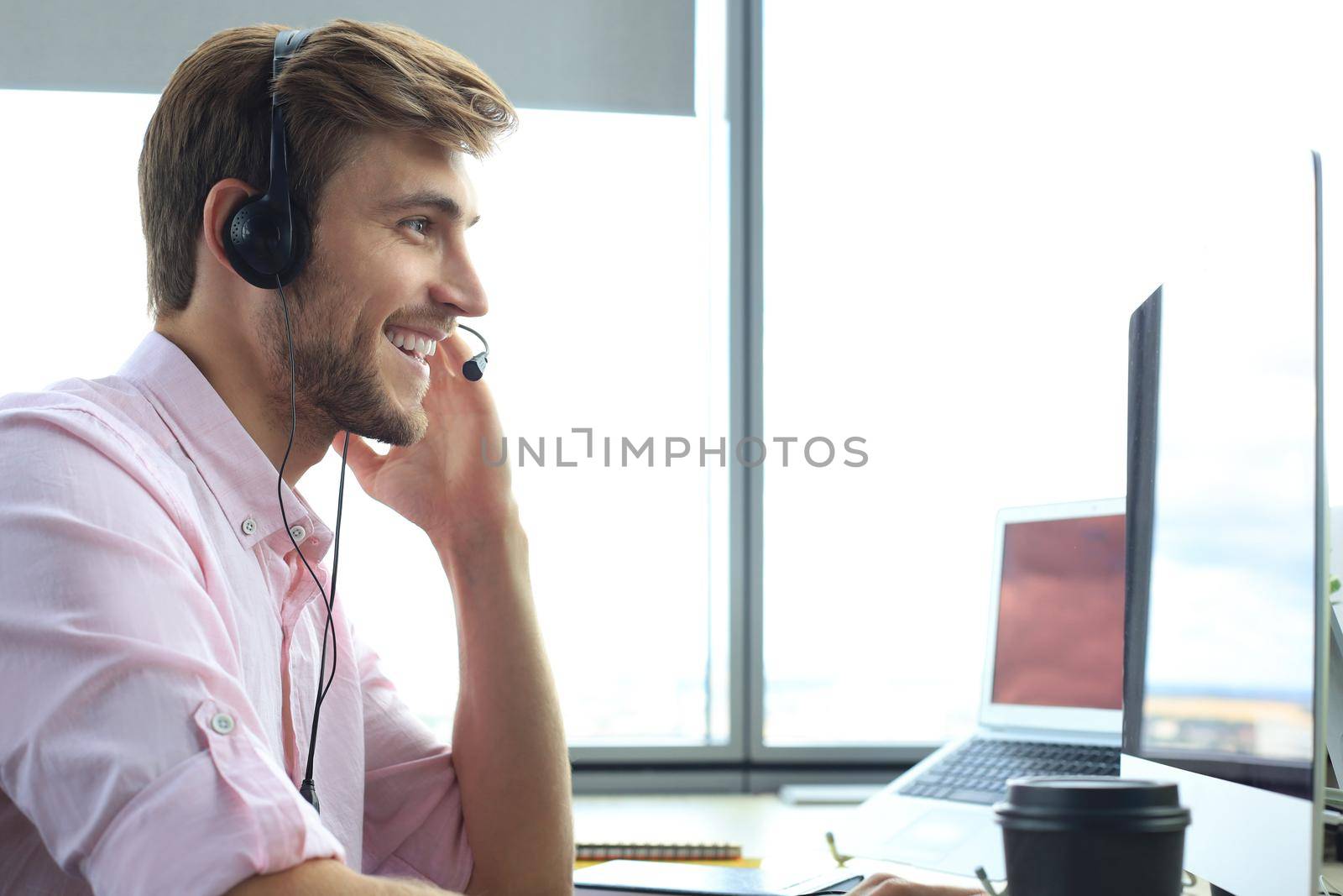 Happy young male customer support executive working in office