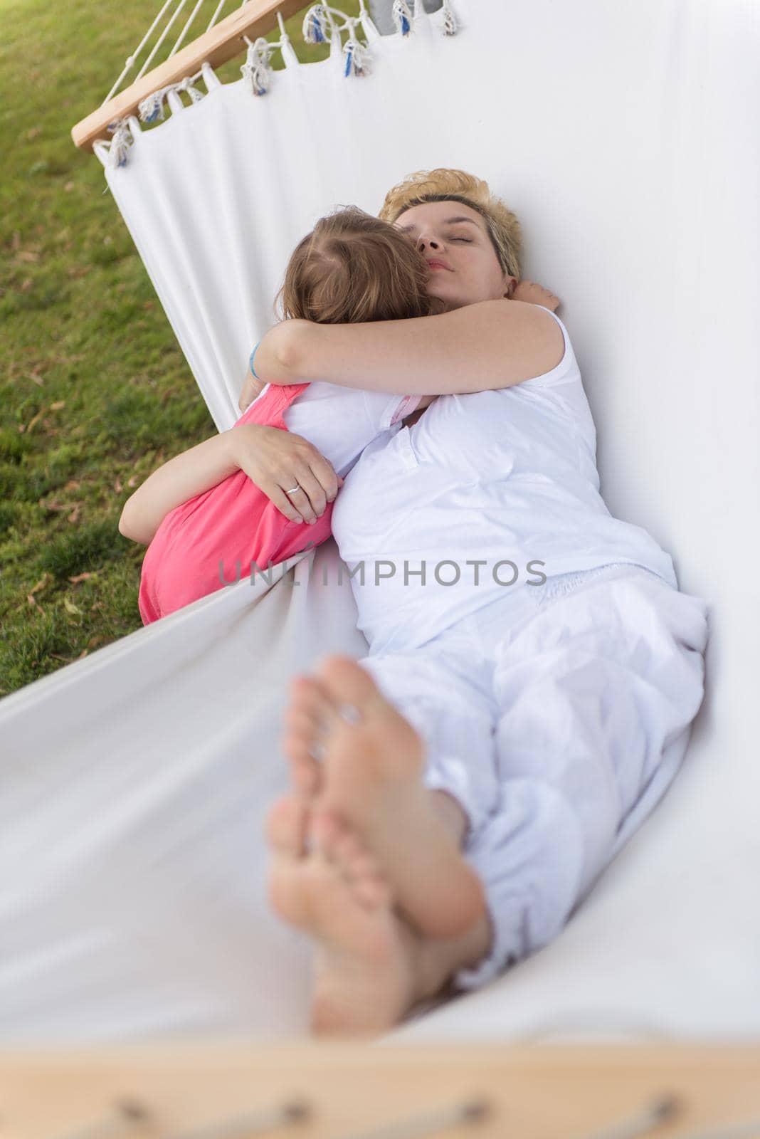 mother and a little daughter relaxing in a hammock by dotshock