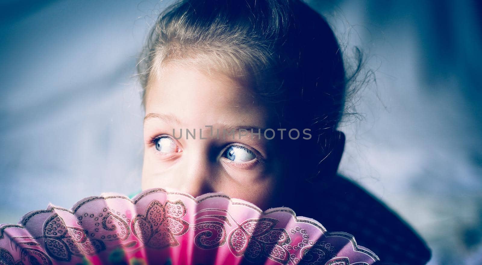 portrait - cute on bright background little girl with a fan .the photo has a empty space for your text