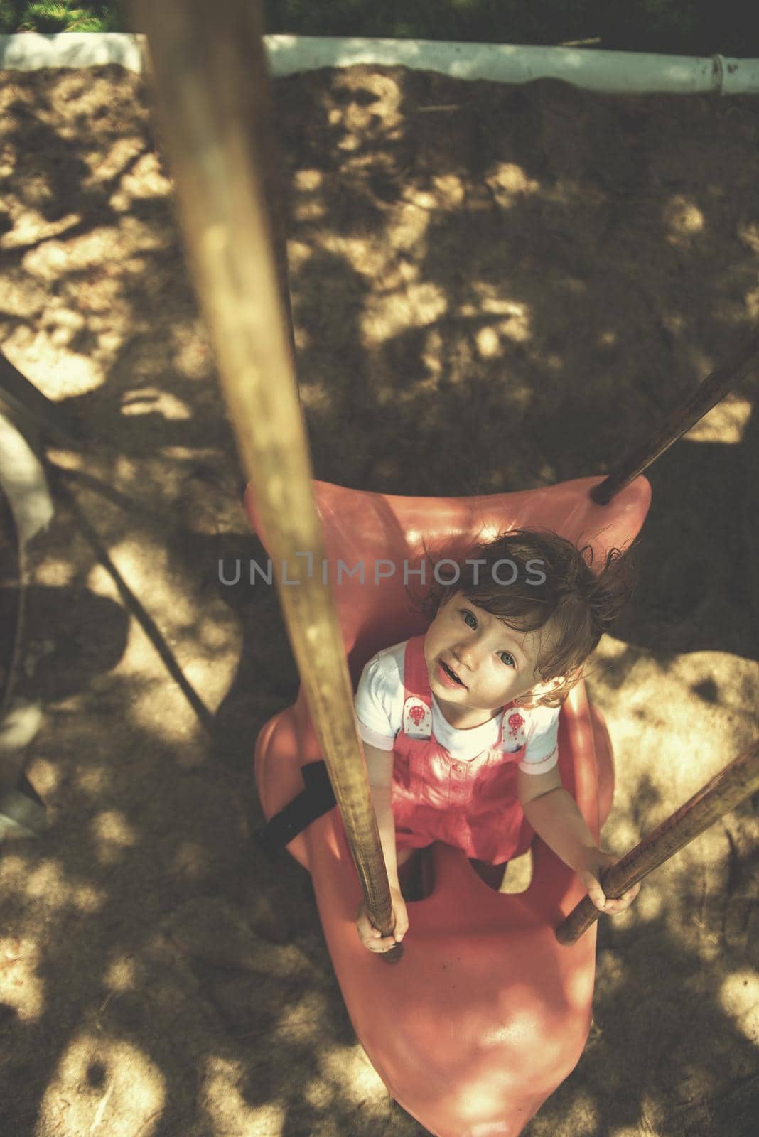 little girl swinging  on a playground by dotshock
