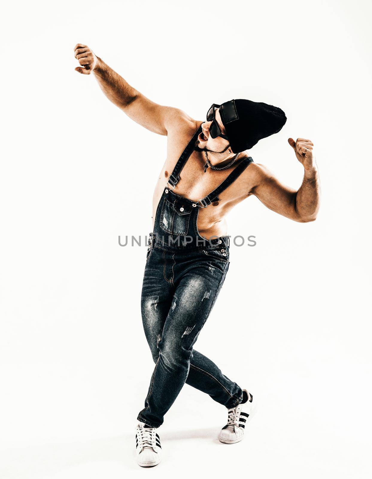 rapper with headphones and dark glasses performs a rap song and break dancing .photo on a light background and has an empty space for your text