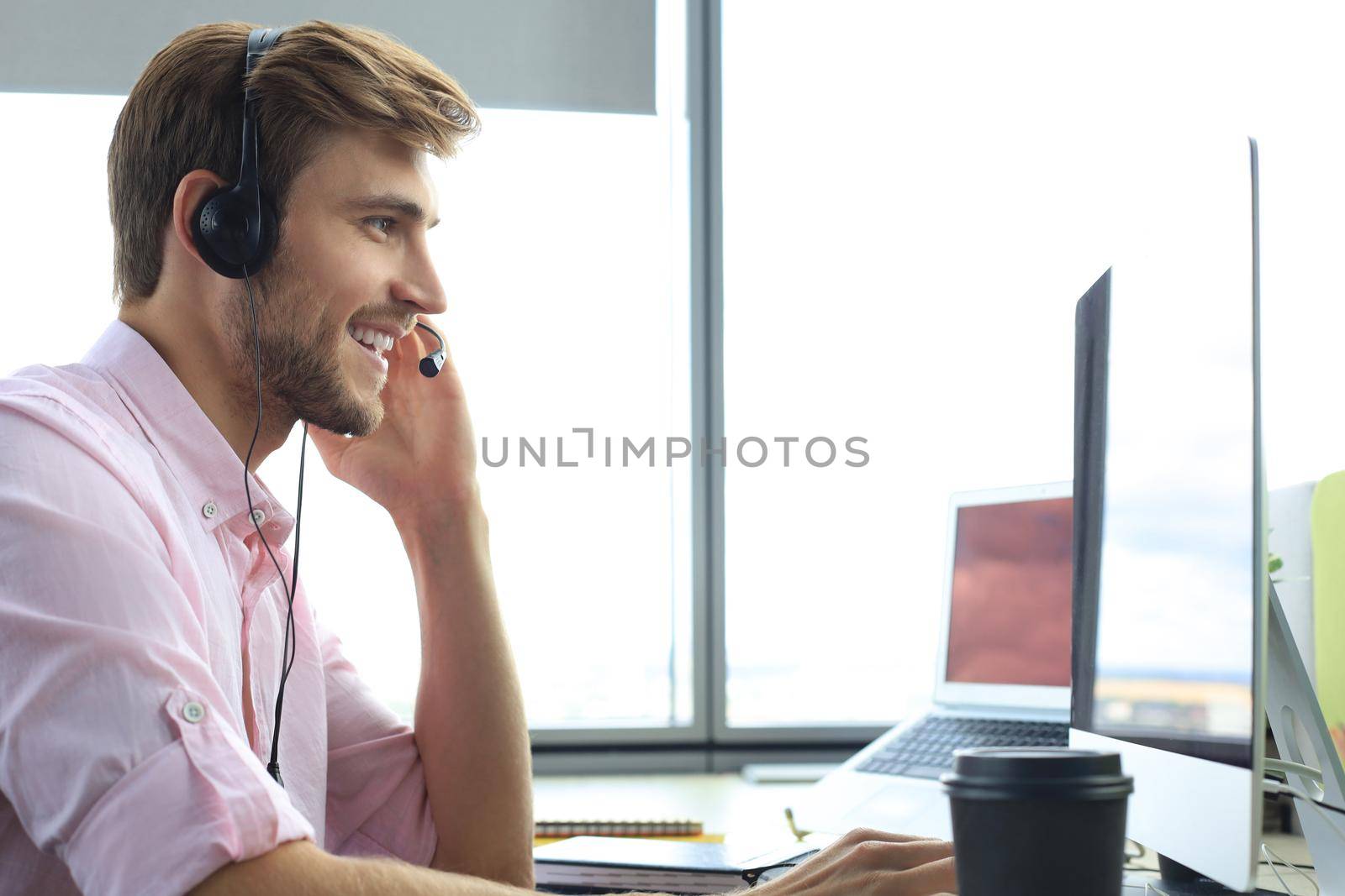 Happy young male customer support executive working in office