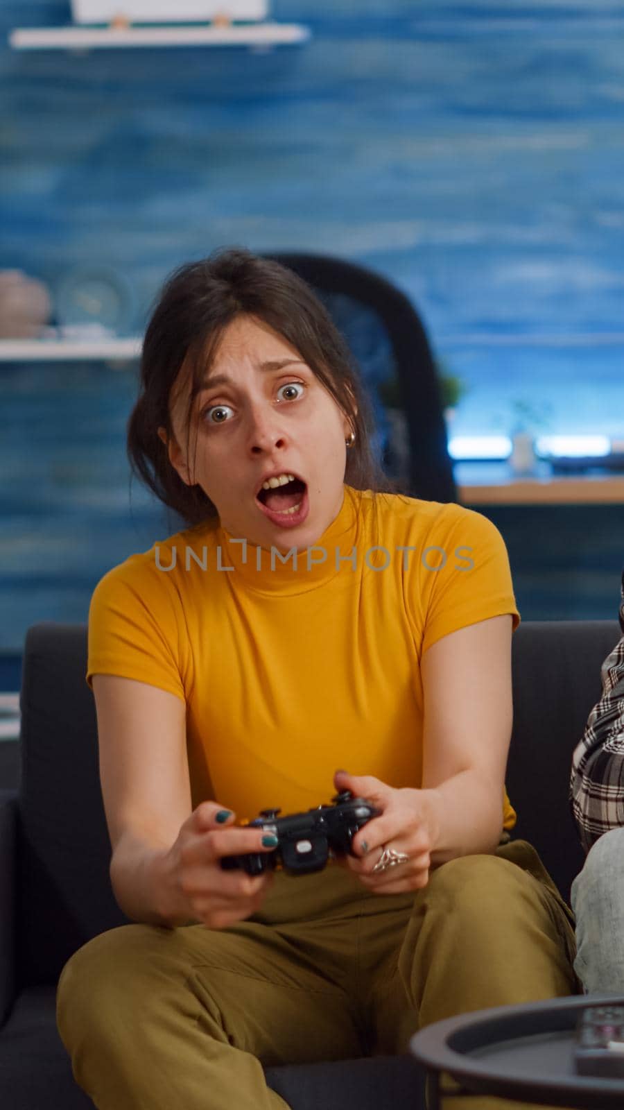 POV of interracial couple playing video game on console in living room. Young multi ethnic people highfive while winning at home. Mixed race partners enjoying fun activity on television
