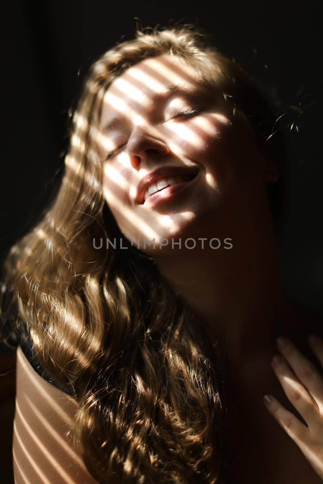 Close up portrait of young nice girl with closed eyes and striped shadows. Concept of private photo session and beautiful femaleperson with eveday makeup.