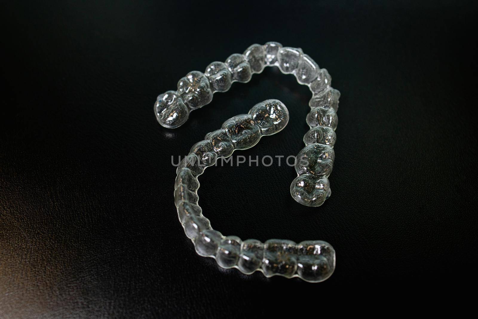 Night guard teeth bruxism protection isolated on the dark background. High quality photo