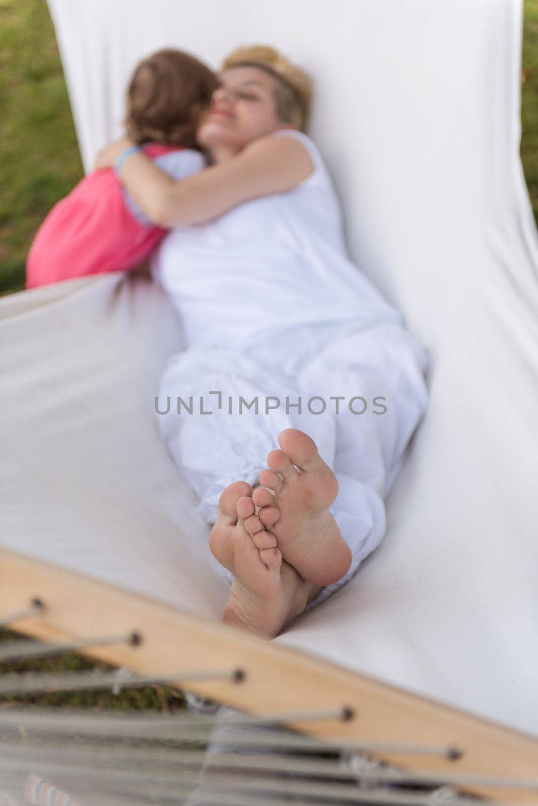 mother and a little daughter relaxing in a hammock by dotshock