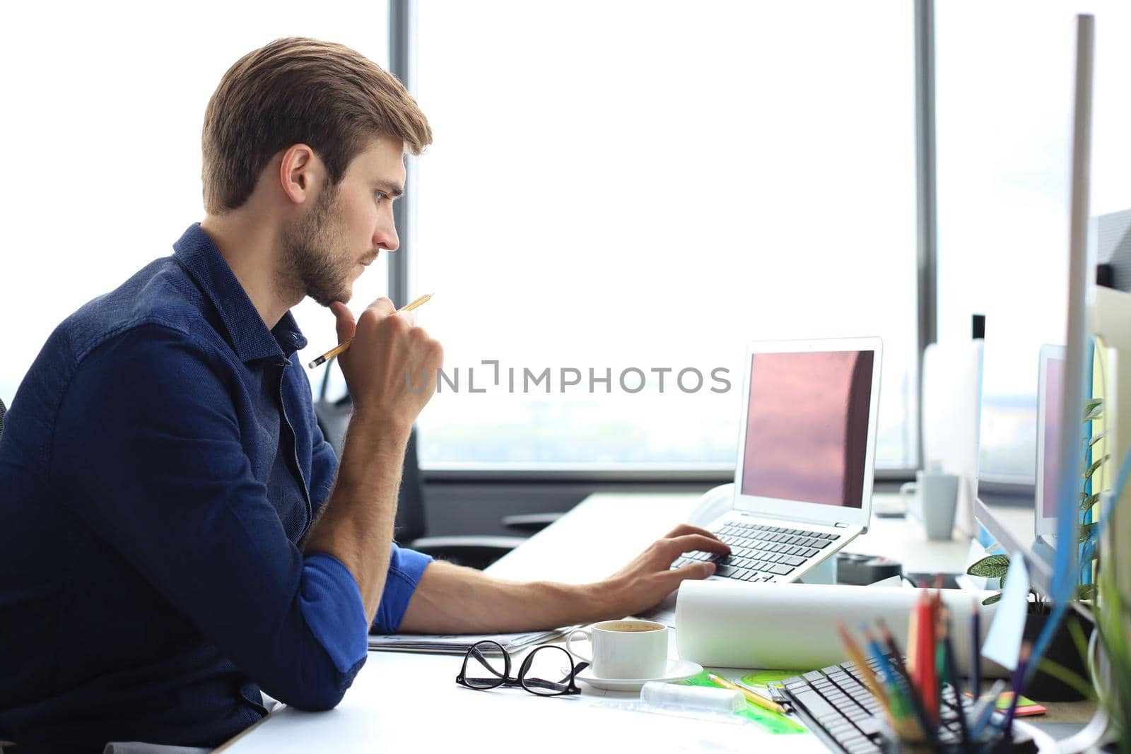 Shot of a handsome male architect working on a design in his office