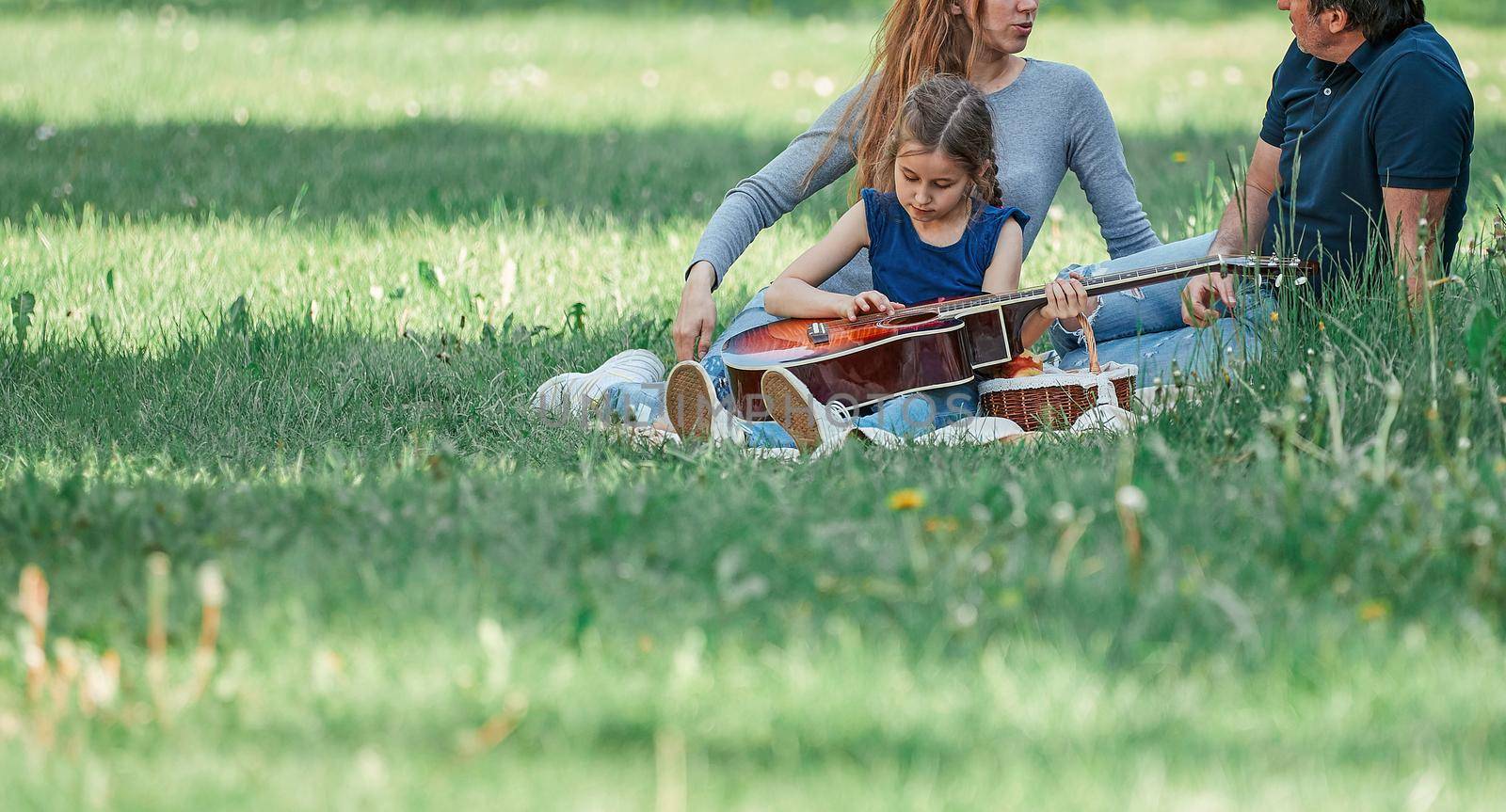 parents with small two children on the lawn on a spring day. good time