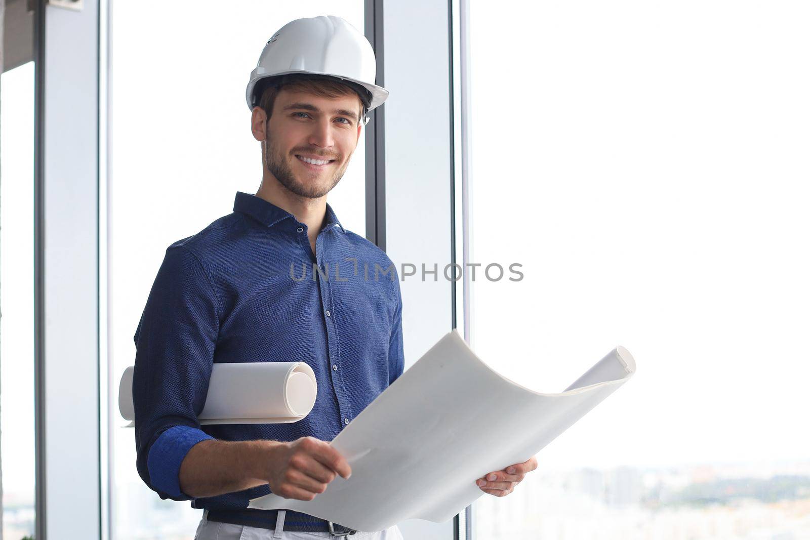 Shot of male architect wearing hardhat and inspecting new building
