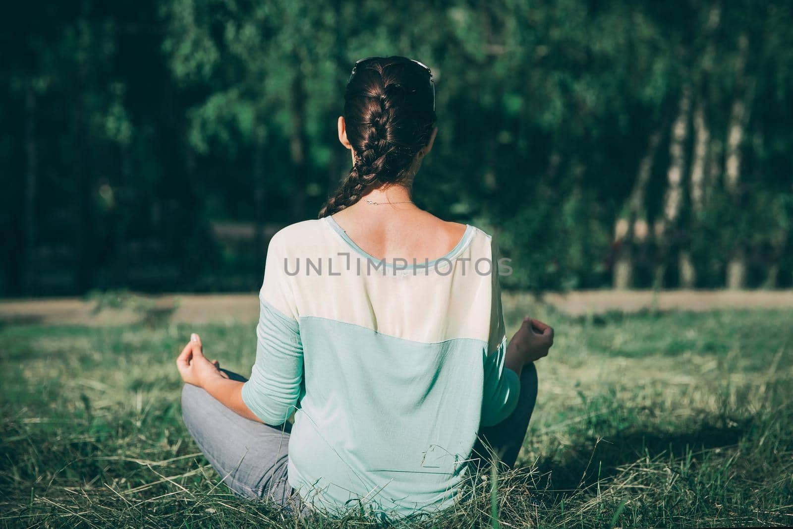 rear view. sporty woman meditating in Lotus position outdoors. the concept of calm and meditation