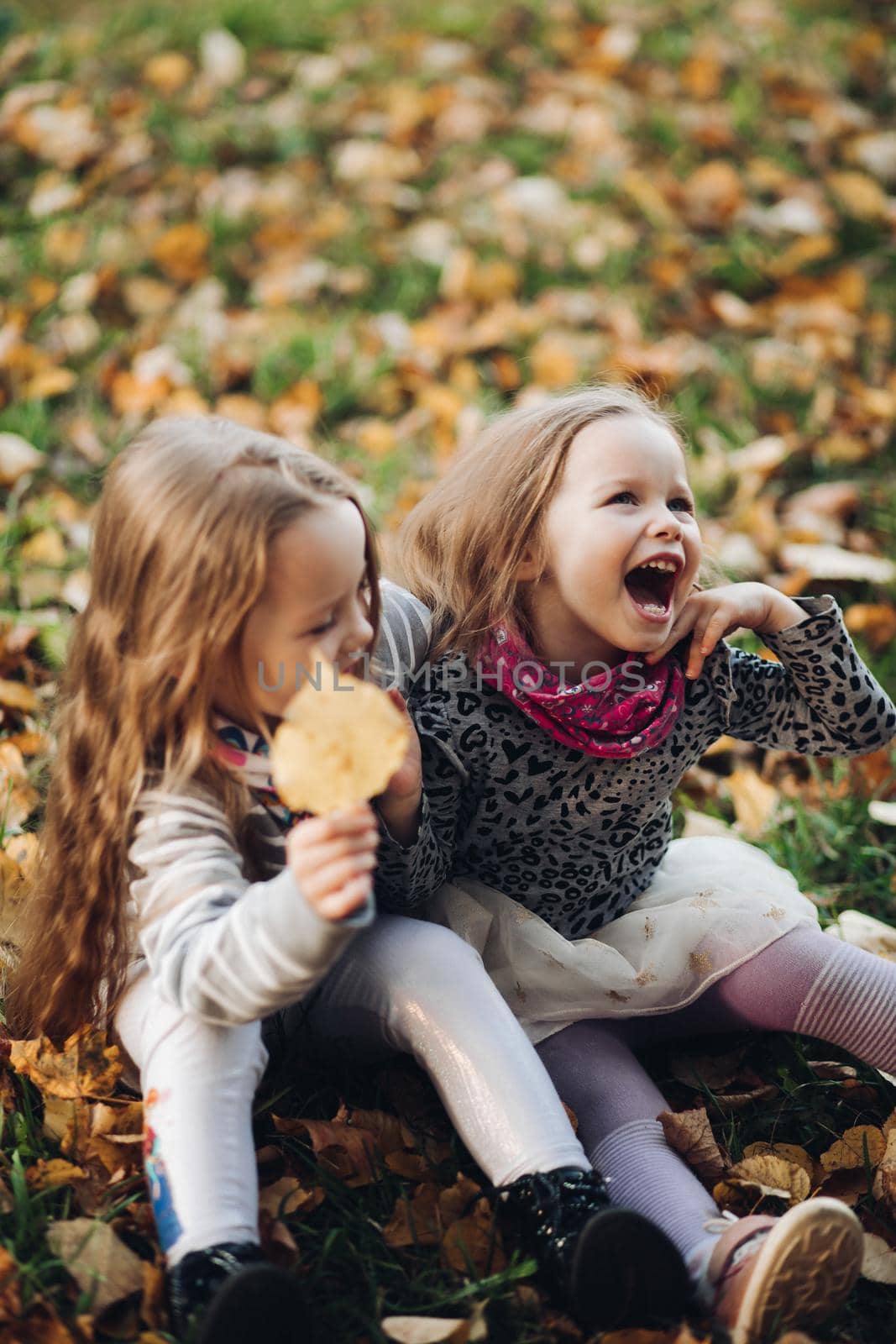 Two beautiful little sisters stand and rejoices with each other by StudioLucky