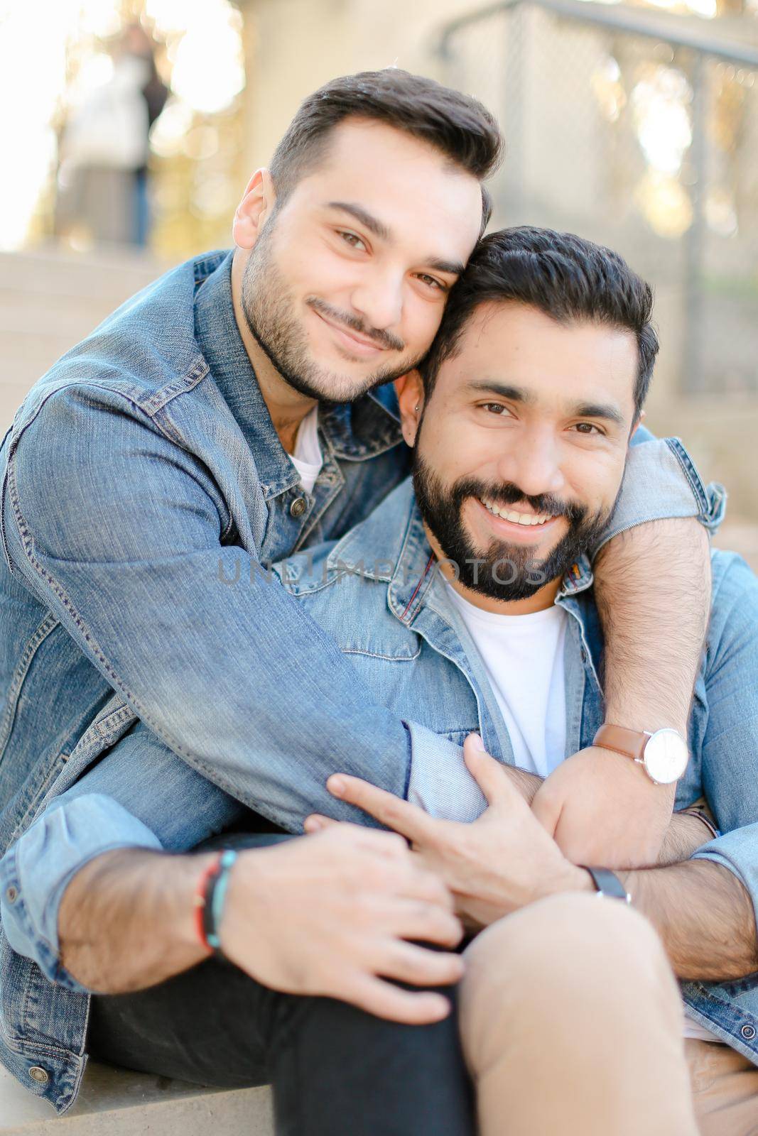Caucasian young happy gays hugging and wearing jeans shirts. Concept of same sex couple and relationship.