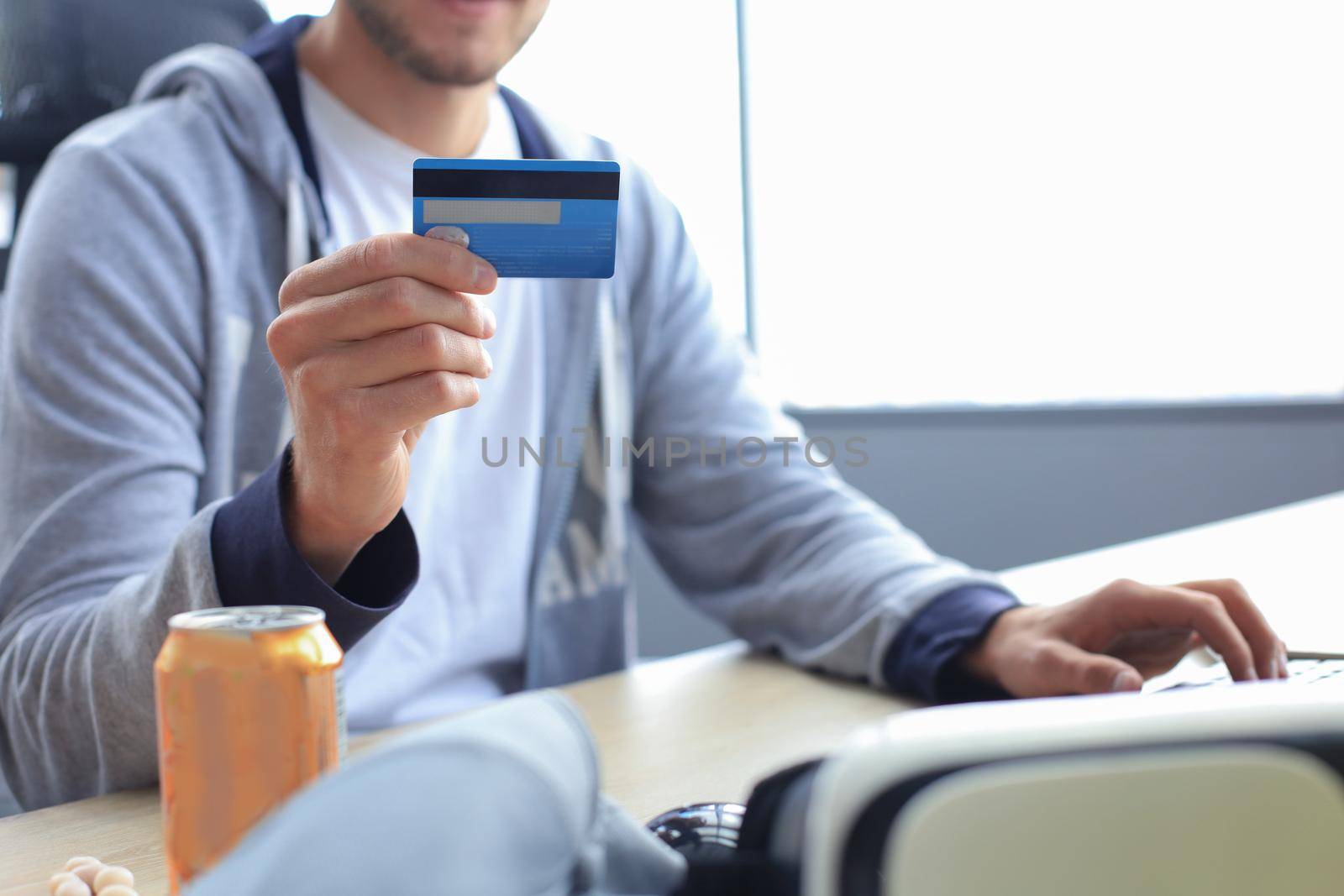 Portrait of a young man holds and using credit card for game money top up. by tsyhun