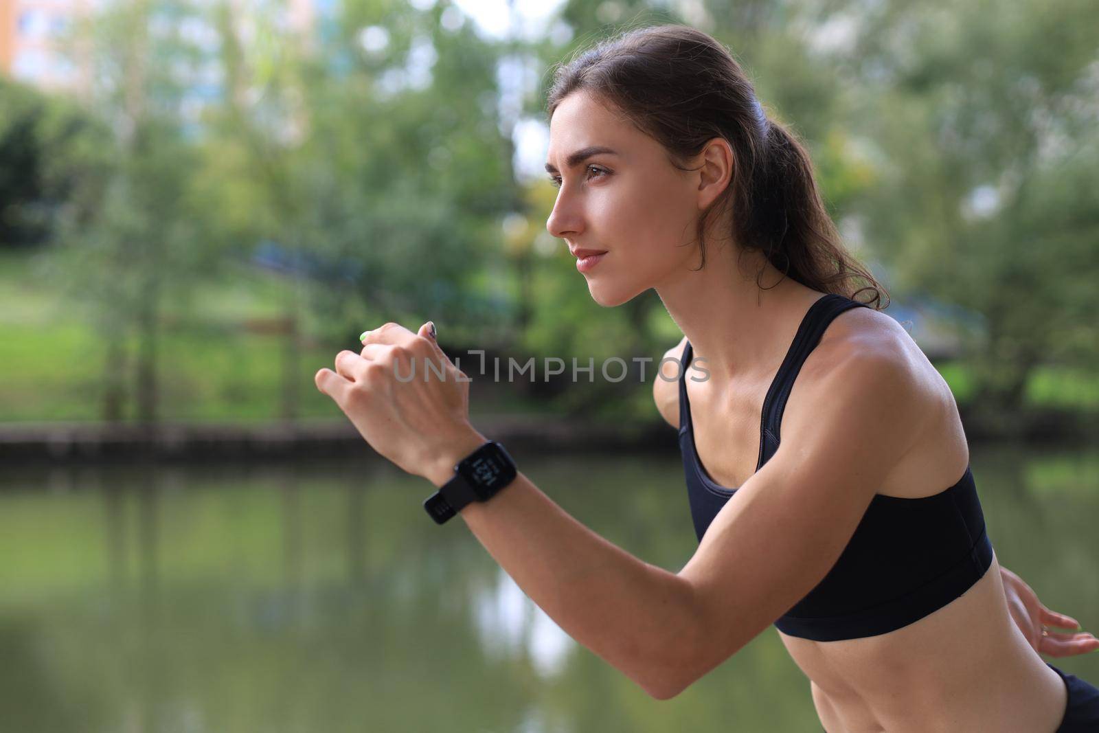 Young woman in sports clothing running while exercising outdoors. by tsyhun