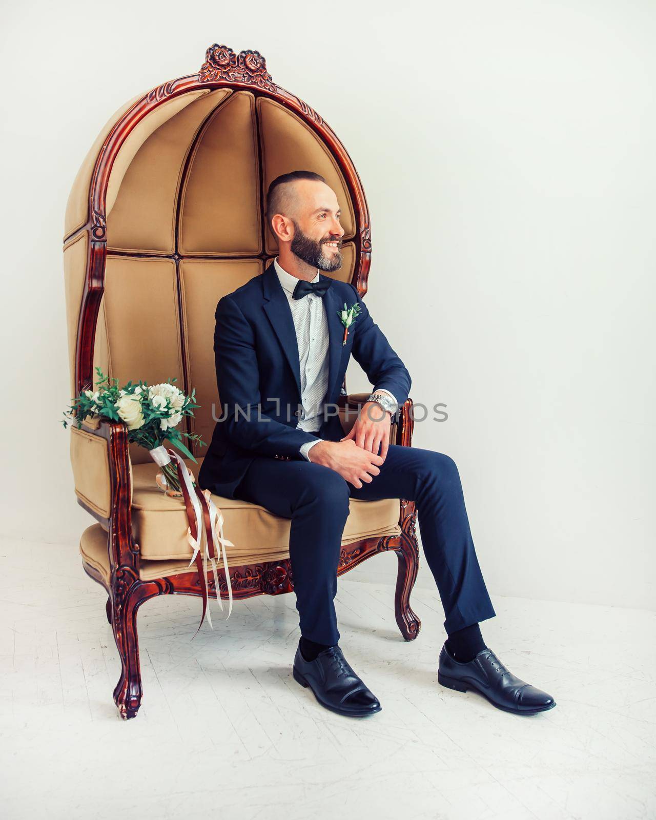 elegant man sitting in a chair and looking somewhere to the side. photo with copy space
