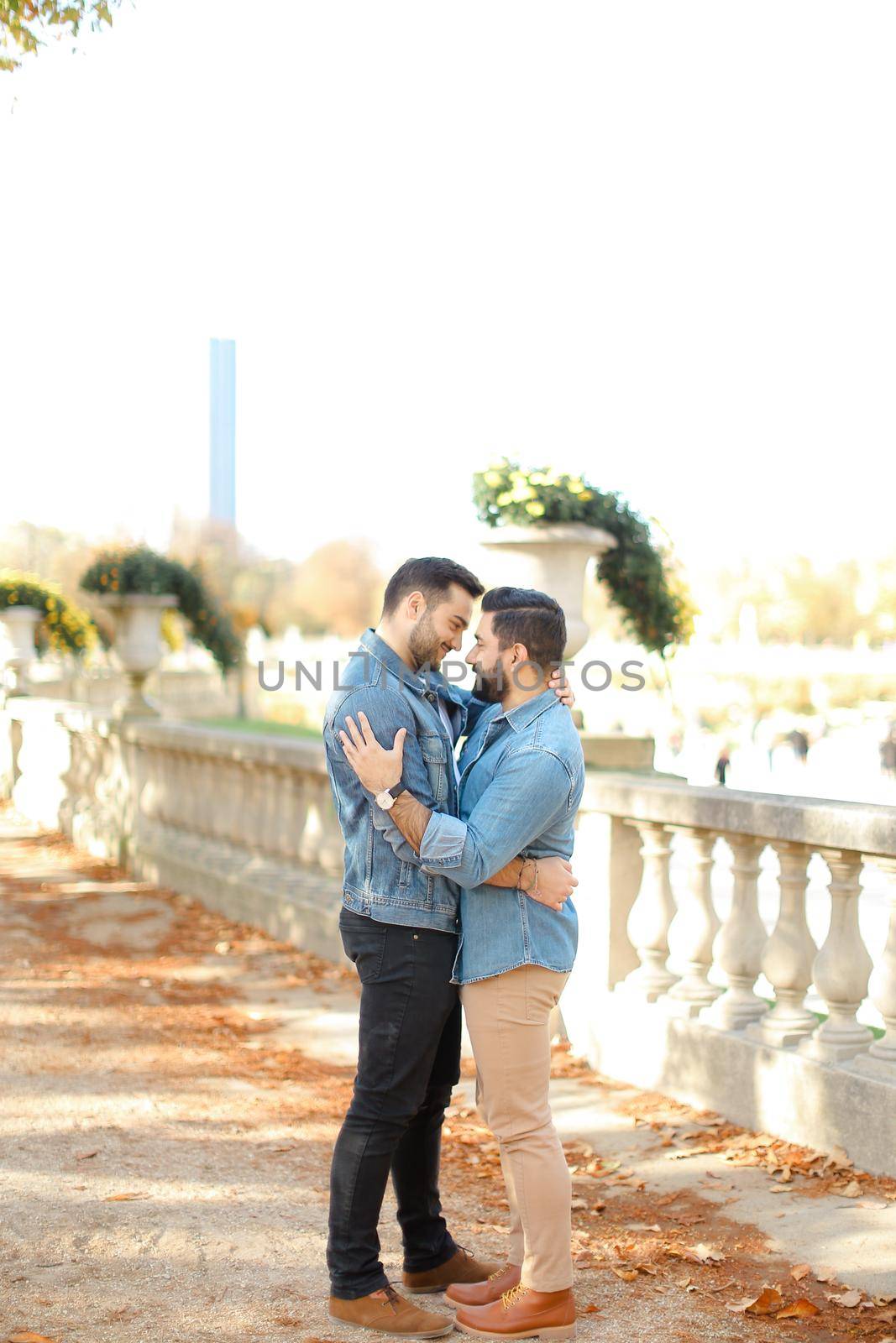 Caucasian young gays walking in park and hugging on concrete stairs. by sisterspro