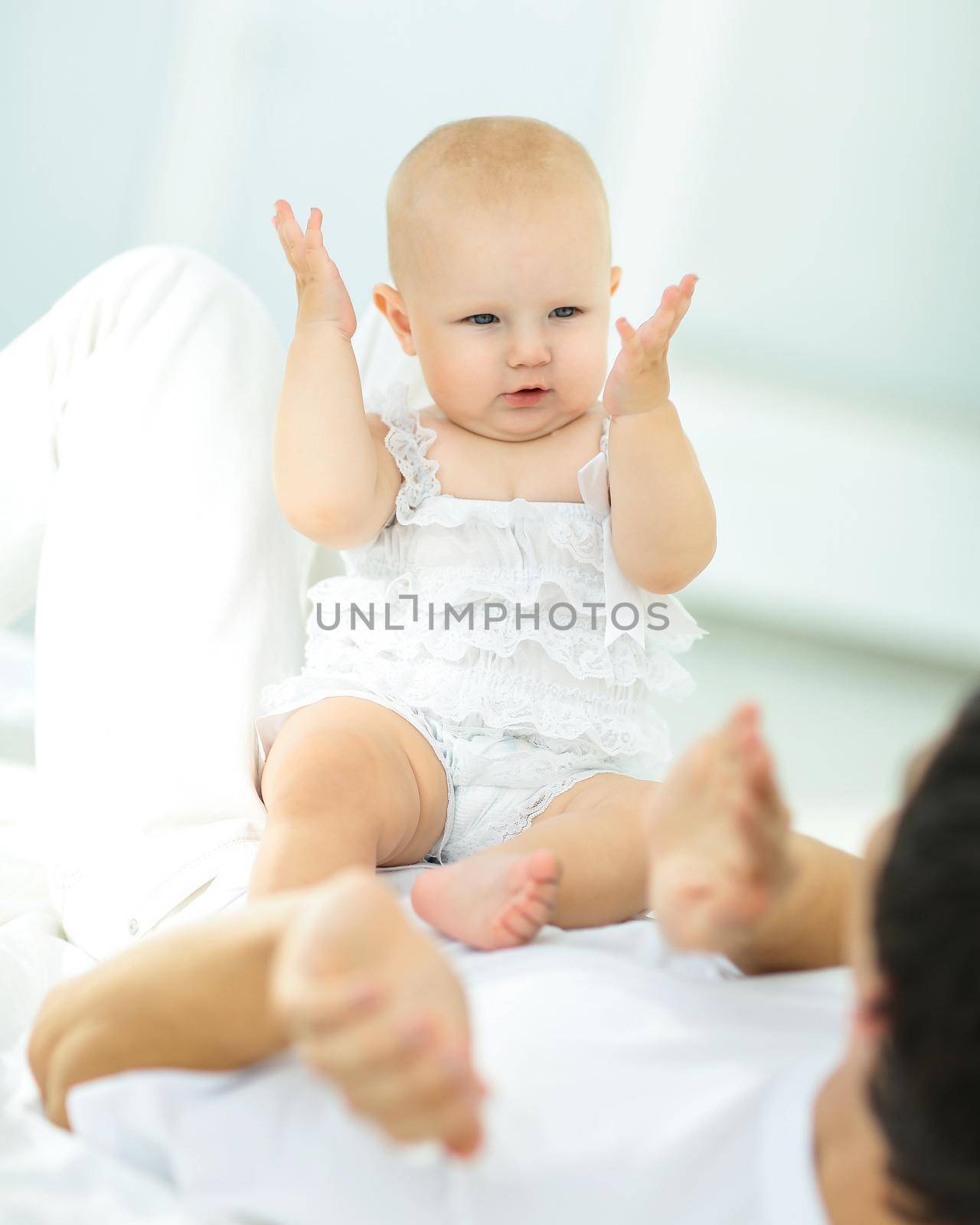 cute baby sitting on the stomach of his father .the concept of fatherhood