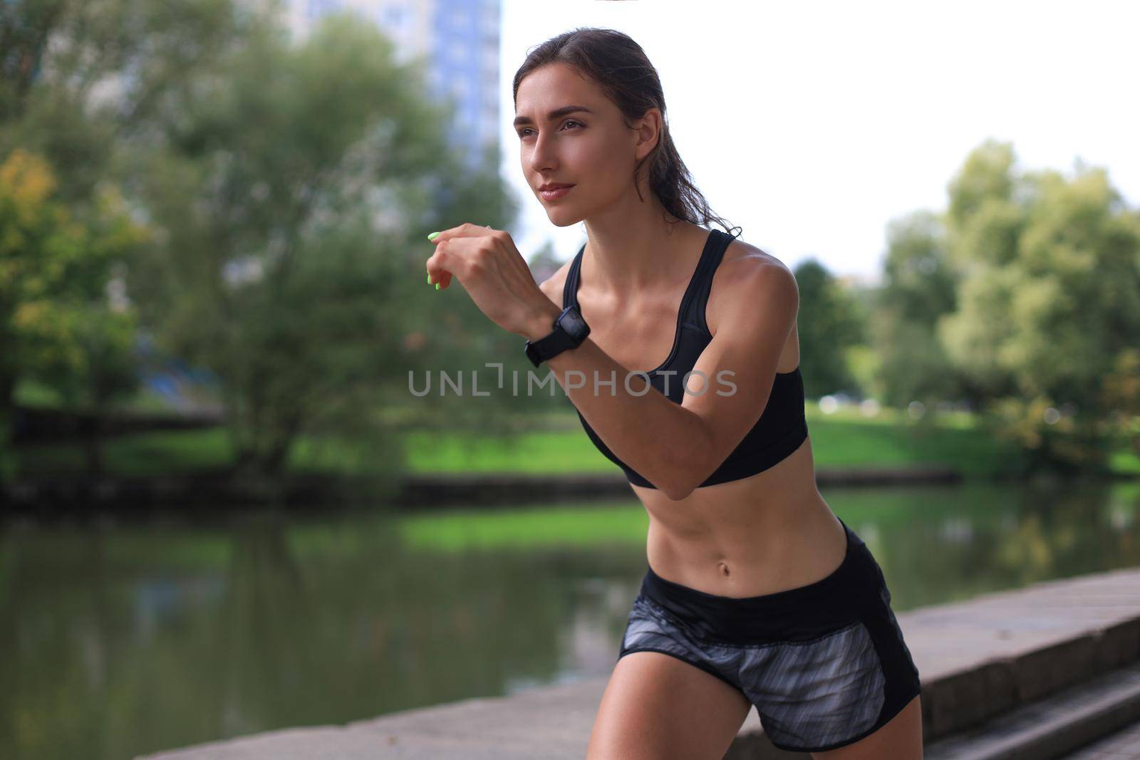 Young woman in sports clothing running while exercising outdoors. by tsyhun