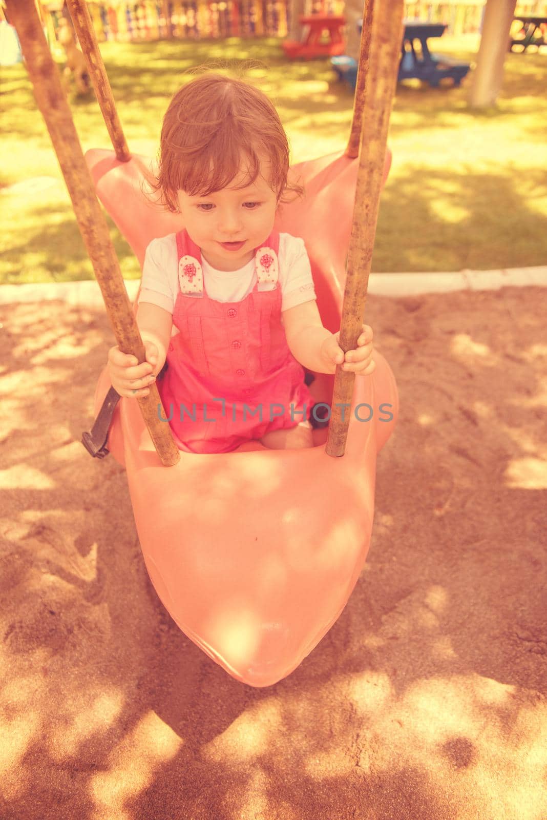 little girl swinging  on a playground by dotshock