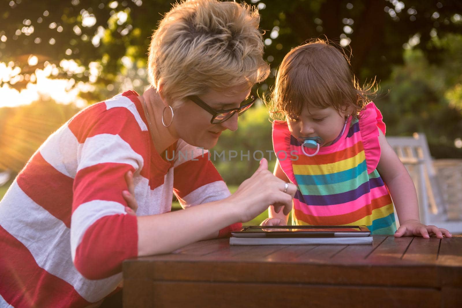 mom and her little daughter using tablet computer by dotshock
