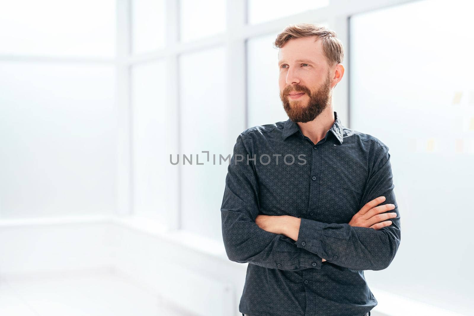 successful businessman standing near the office window. photo with copy space