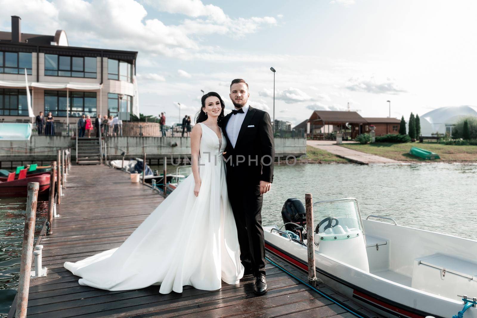 happy bride and groom standing on the pier. holidays and events