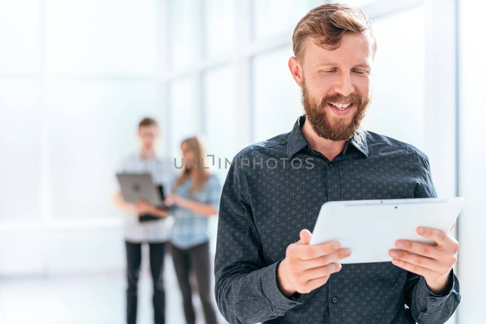 smiling businessman looking at the screen of his digital tablet. photo with copy space