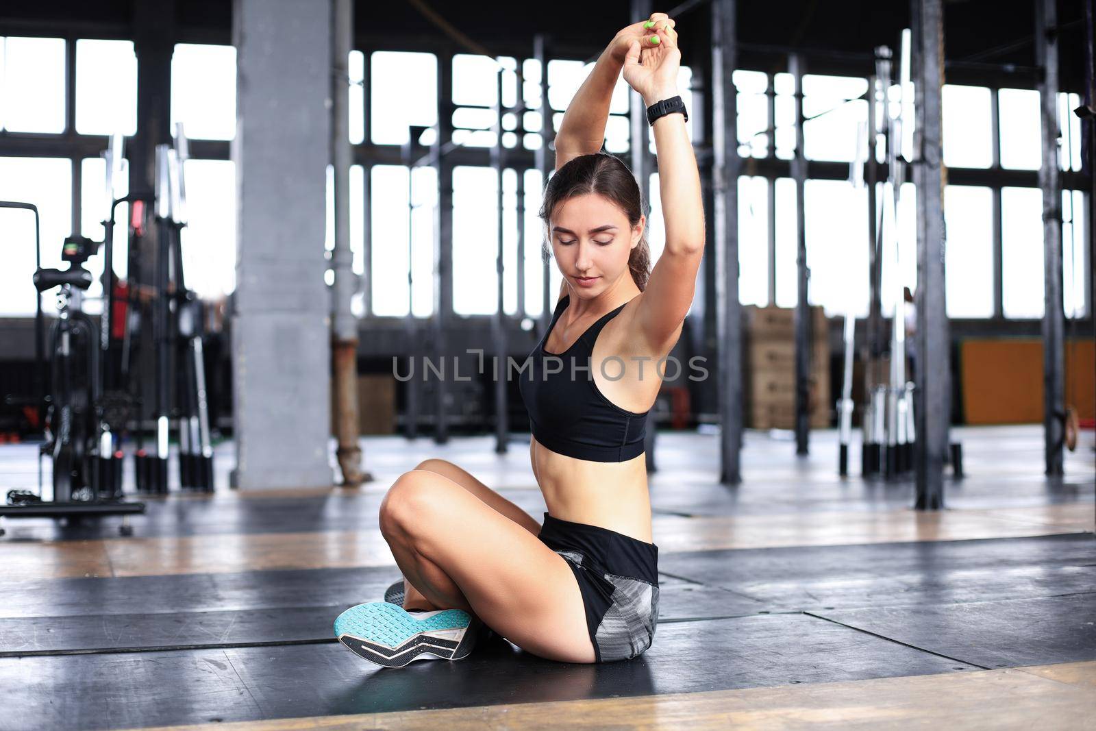 Young sporty woman stretching at the gym