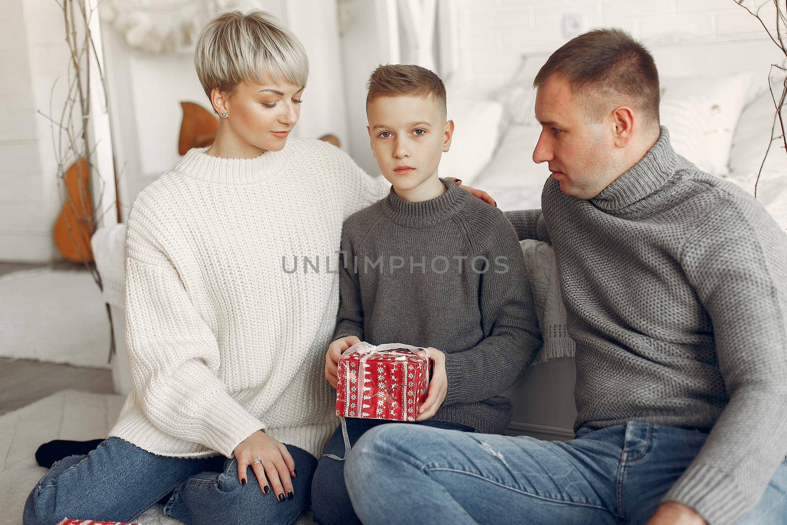 Family in a room. Little boy near christmas decoration. Mother with father with son