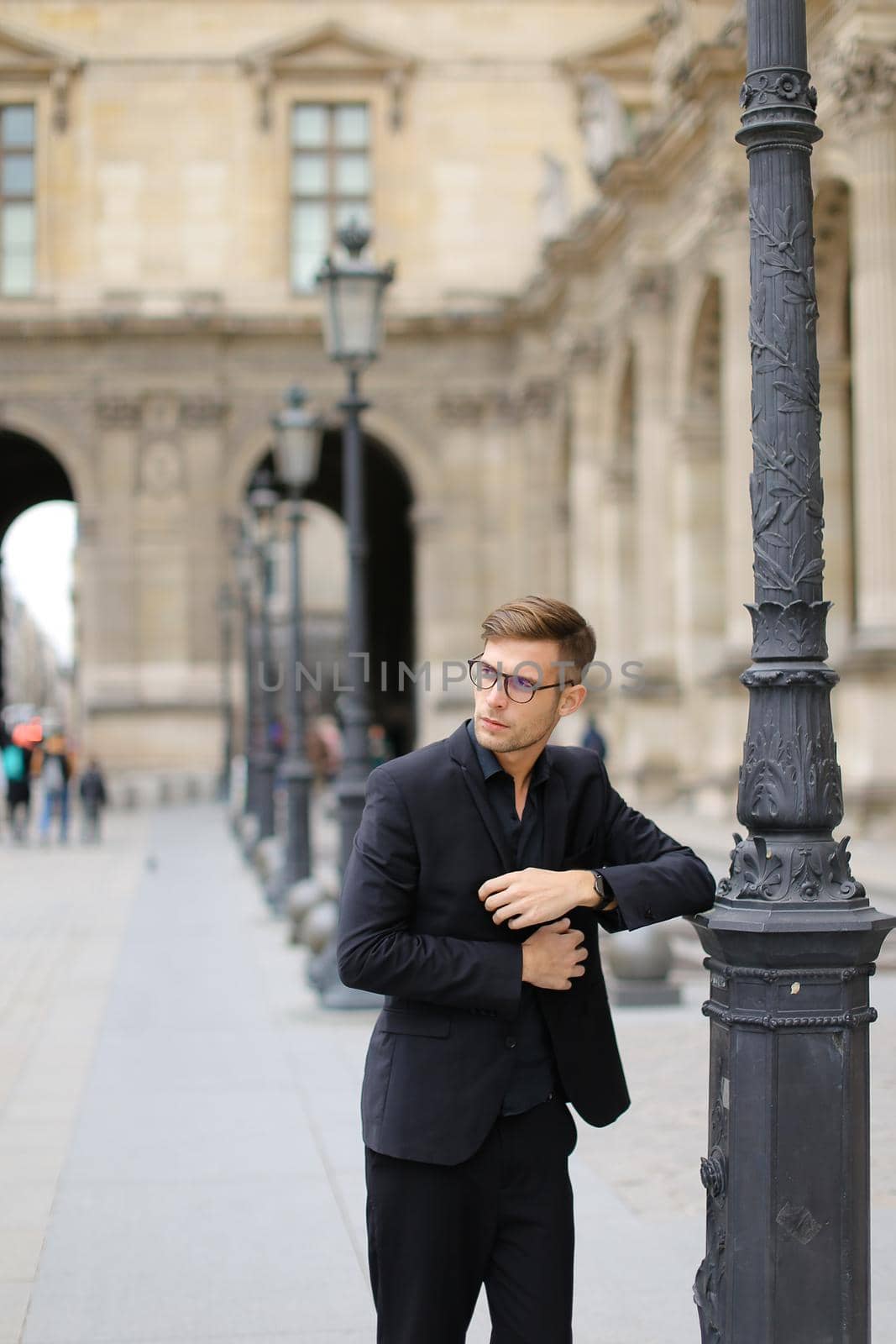 Young man walking in Paris and leaning on lantern, weaaring suit. by sisterspro