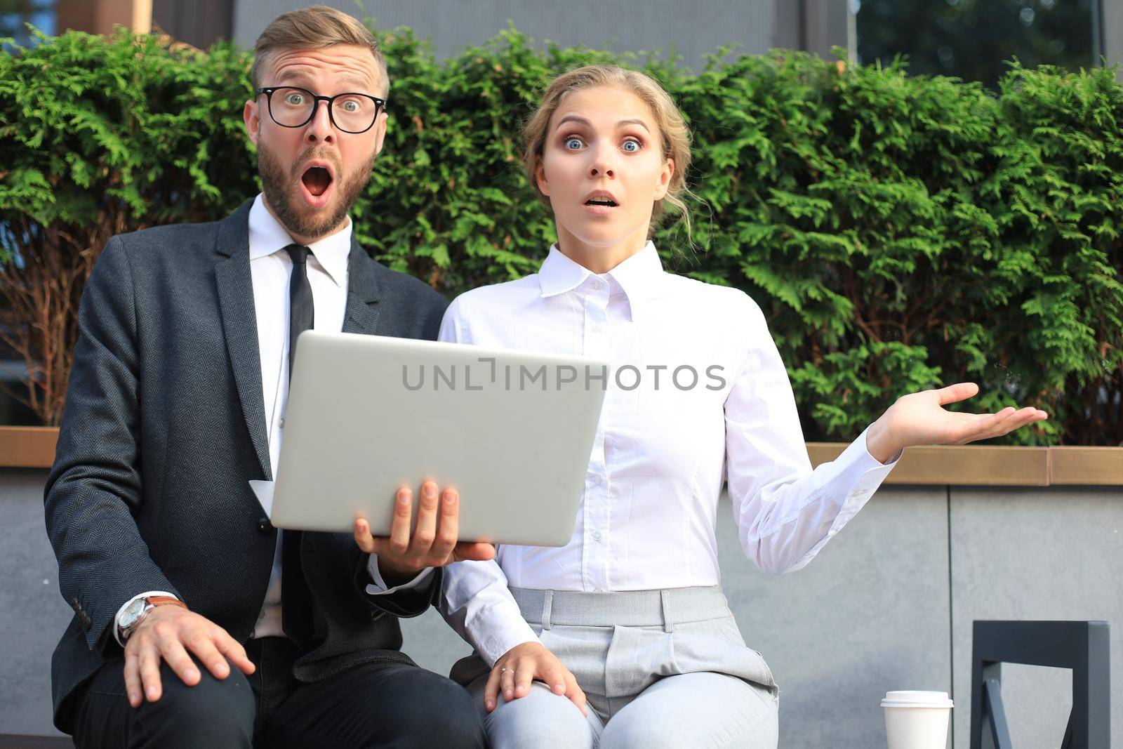 Business people shocked by information from laptop