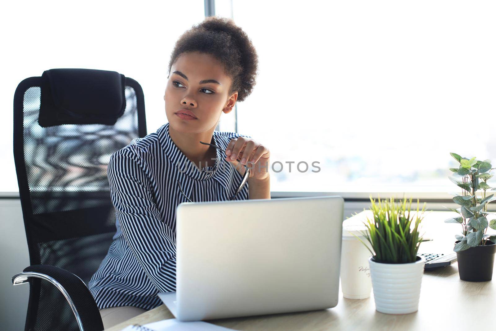 Portrait of beautiful young african american woman working with laptop while sitting at the table