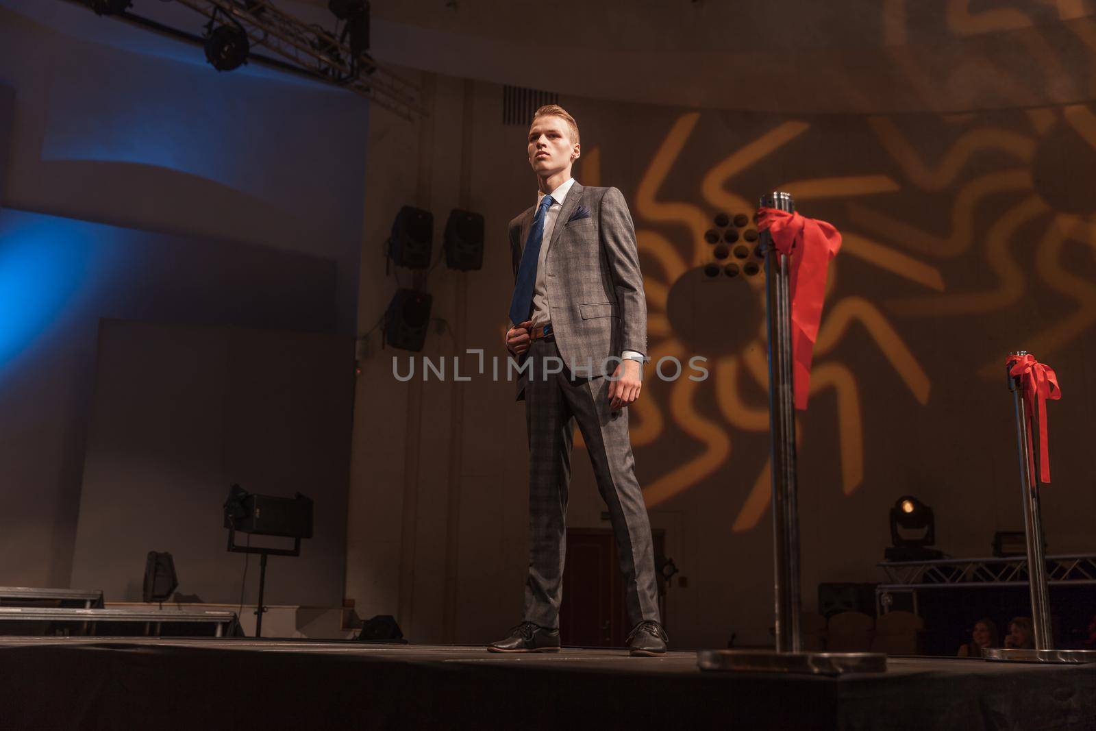 stylish male model standing on the catwalk during a fashion show