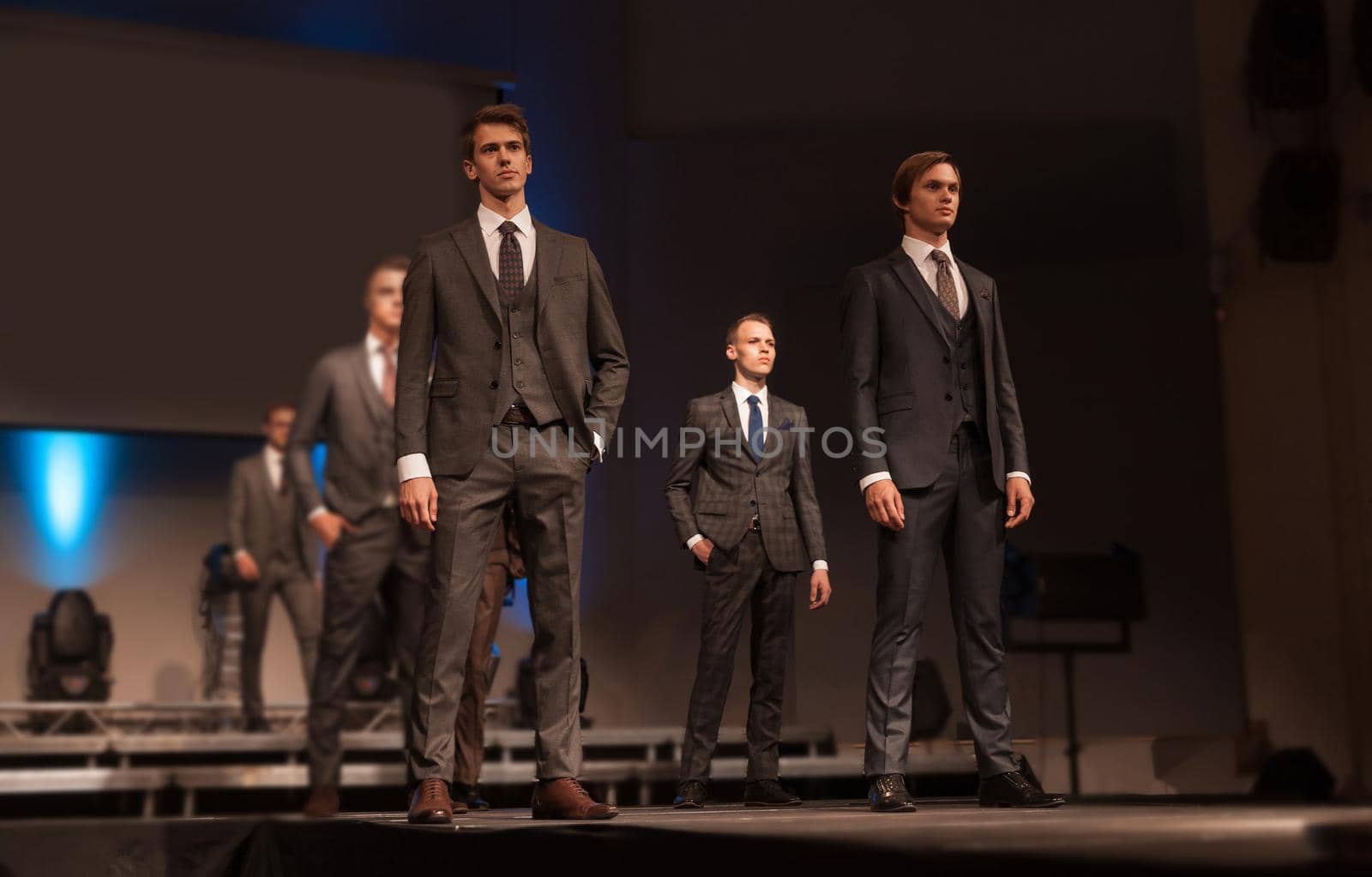 group of attractive male models shows a new collection of clothes. fashion show