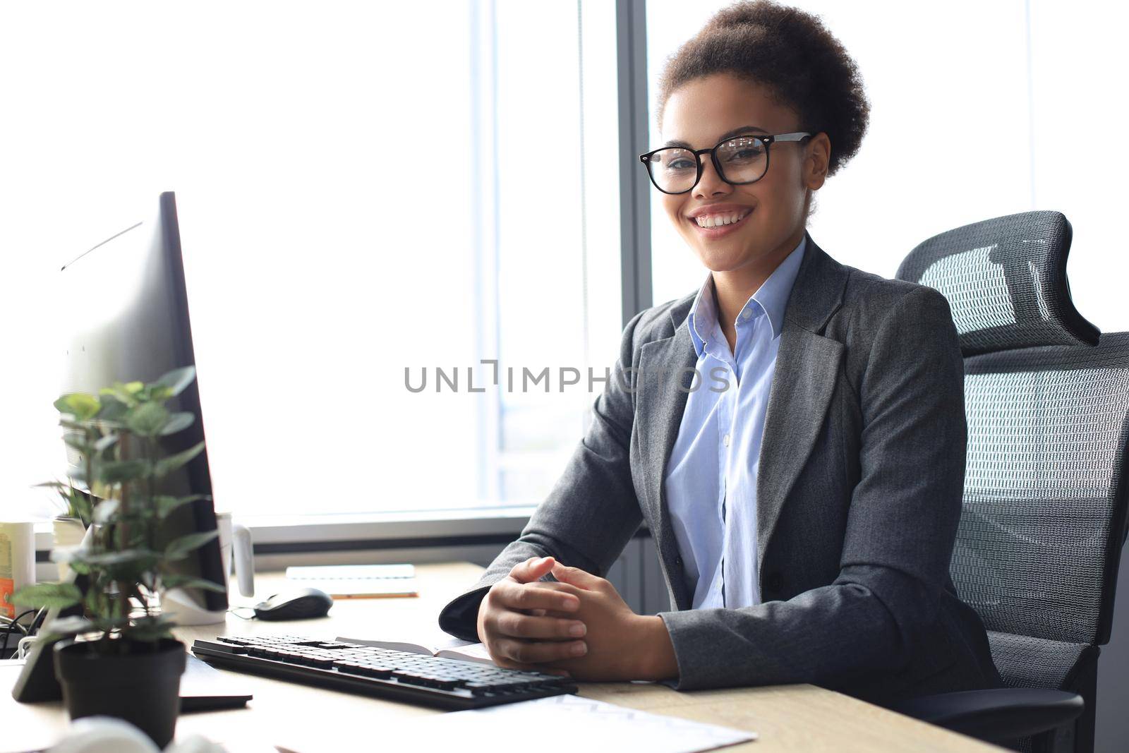 Portrait of beautiful young african american woman working on computer while sitting at the table