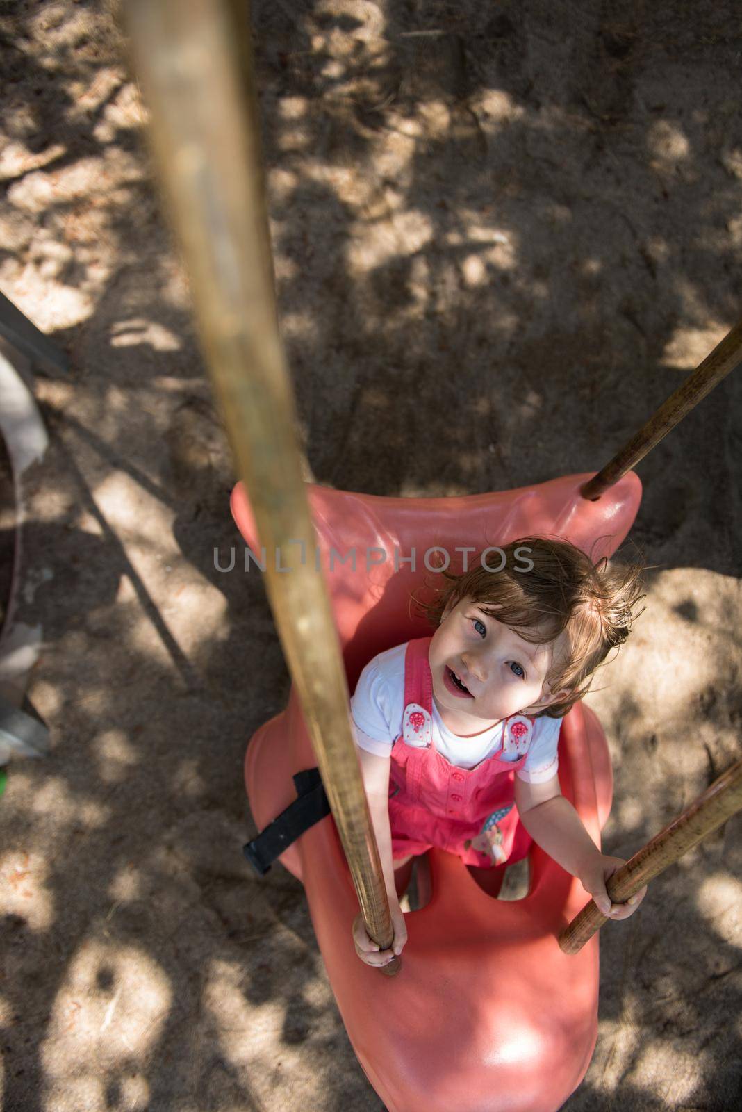 little girl swinging  on a playground by dotshock