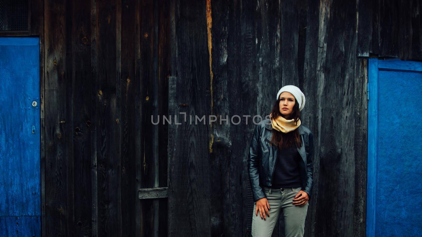 sad young woman standing near an old country house