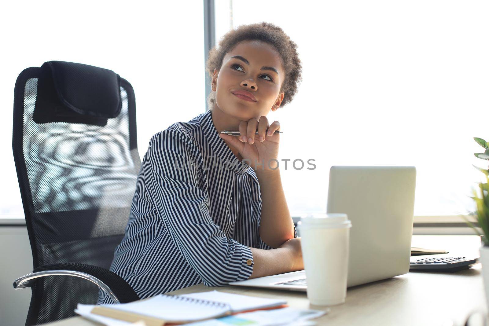 Portrait of beautiful young african american woman working with laptop while sitting at the table