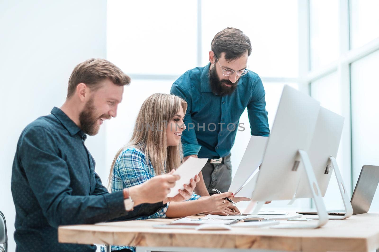 smiling employees checking financial statements . office weekdays
