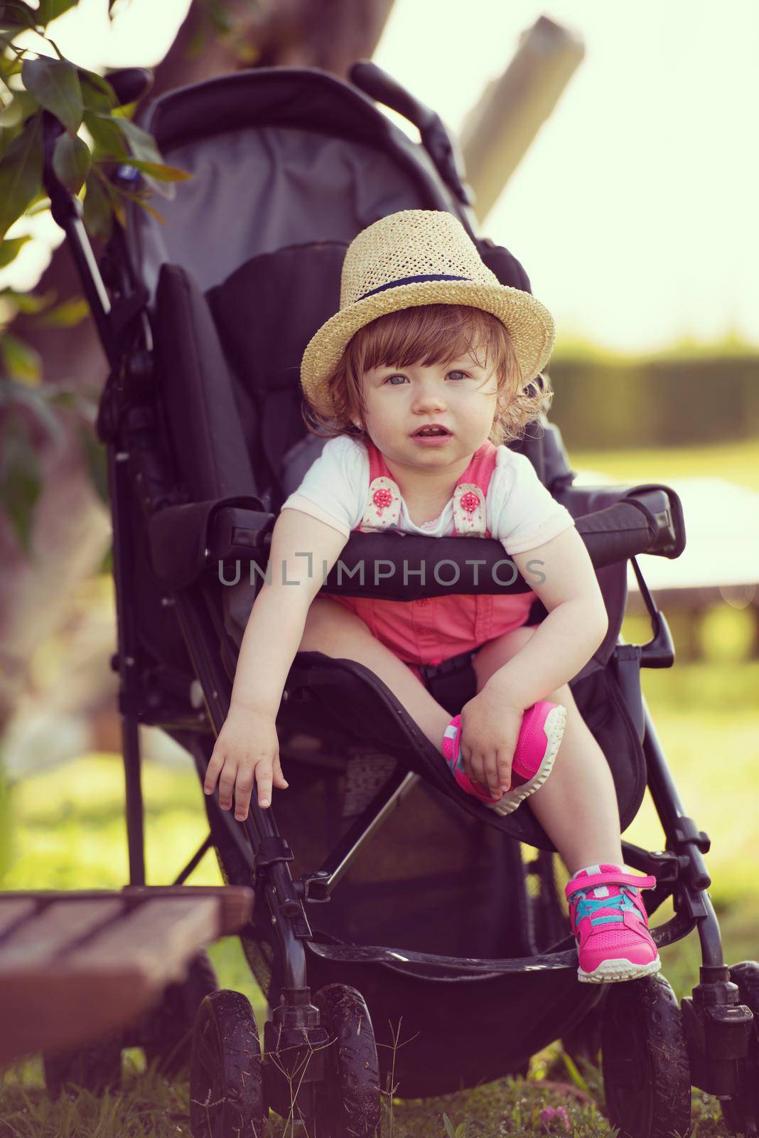baby girl sitting in the baby stroller by dotshock