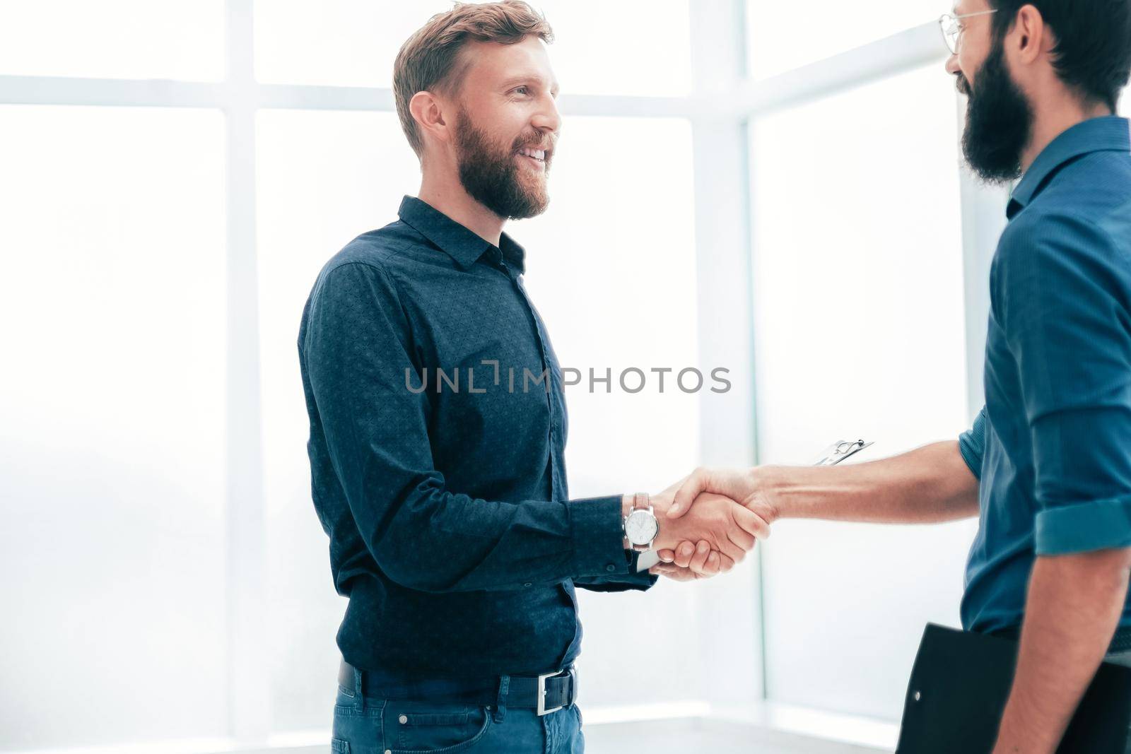 business people shaking hands in a bright office. concept of cooperation