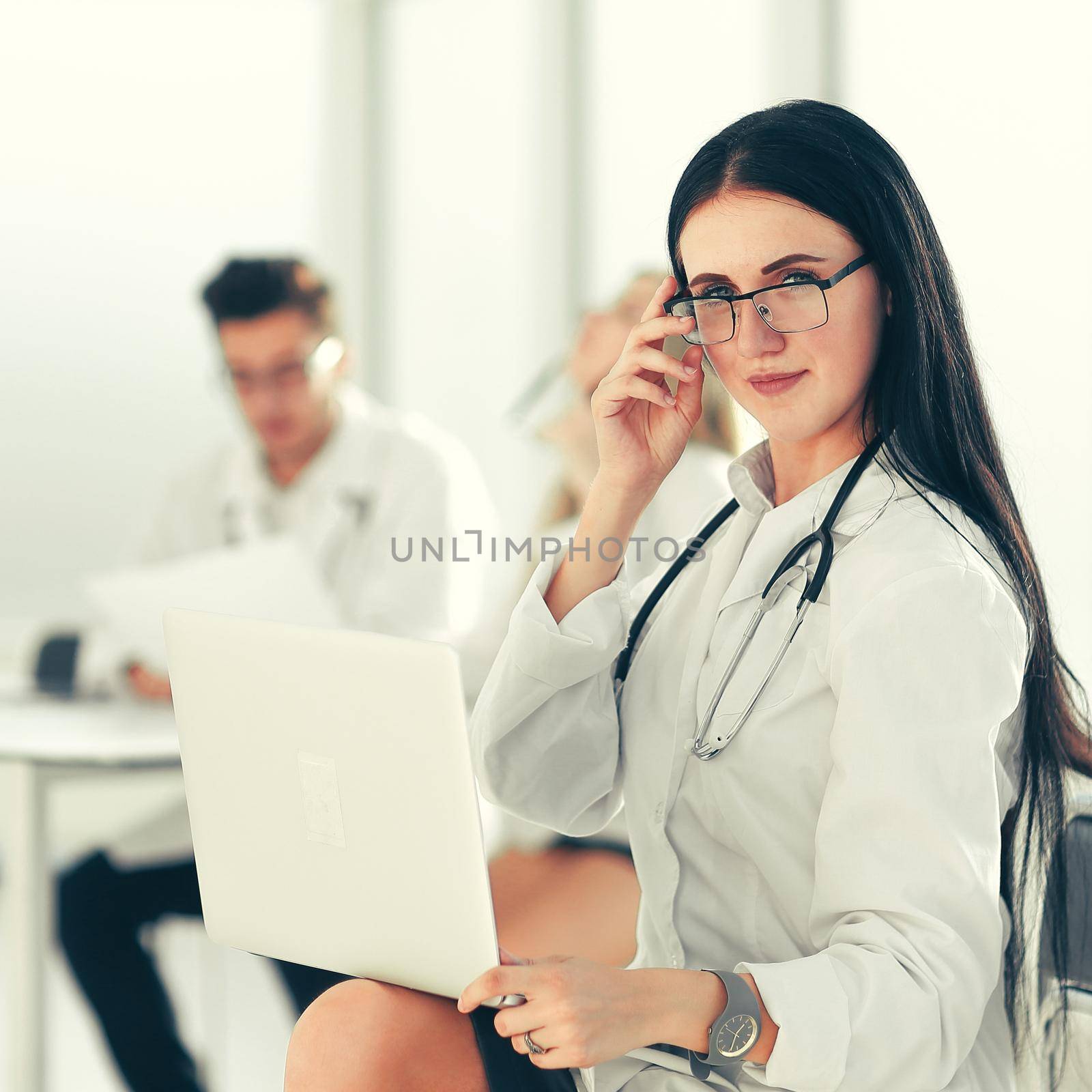 therapist with a laptop sitting in the hospital office by SmartPhotoLab