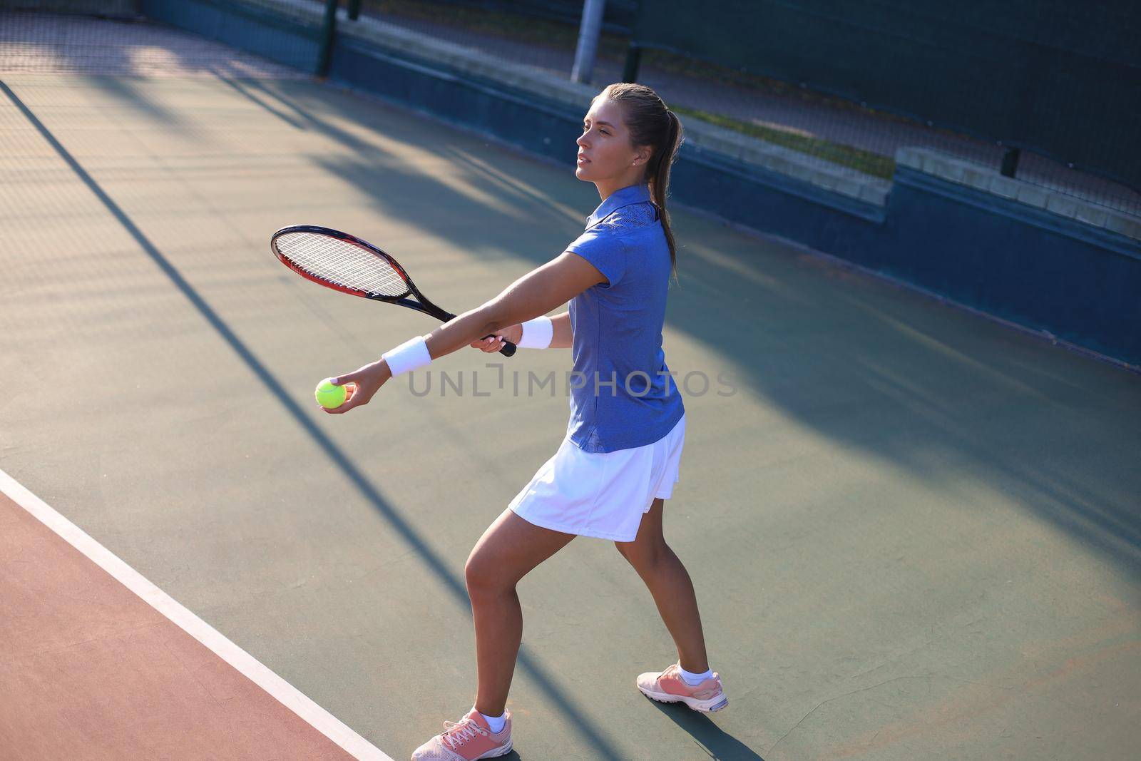 Pretty sportswoman with racquet at the tennis court. Healthy lifestyle